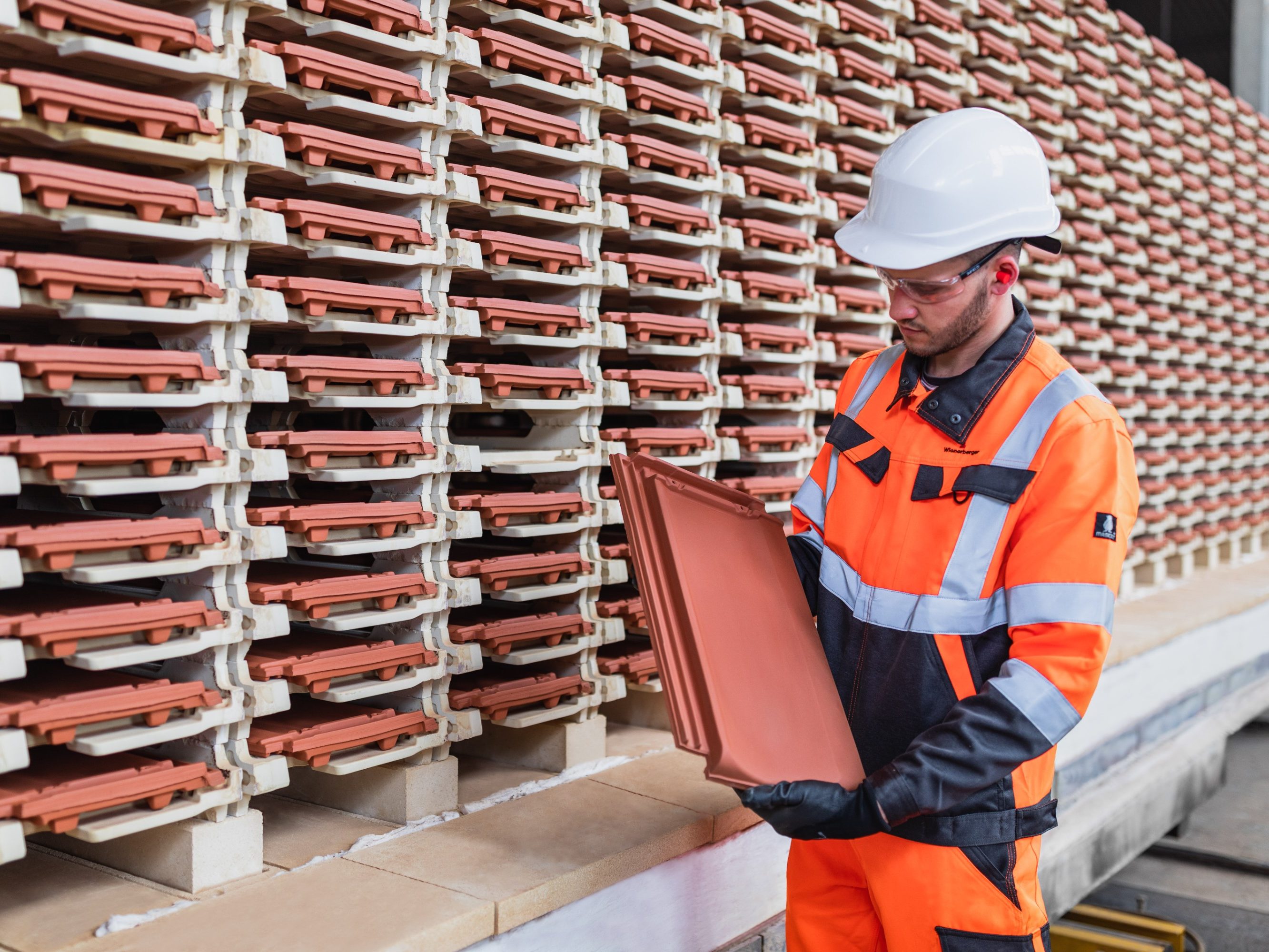 Factory worker checking roof tile quality