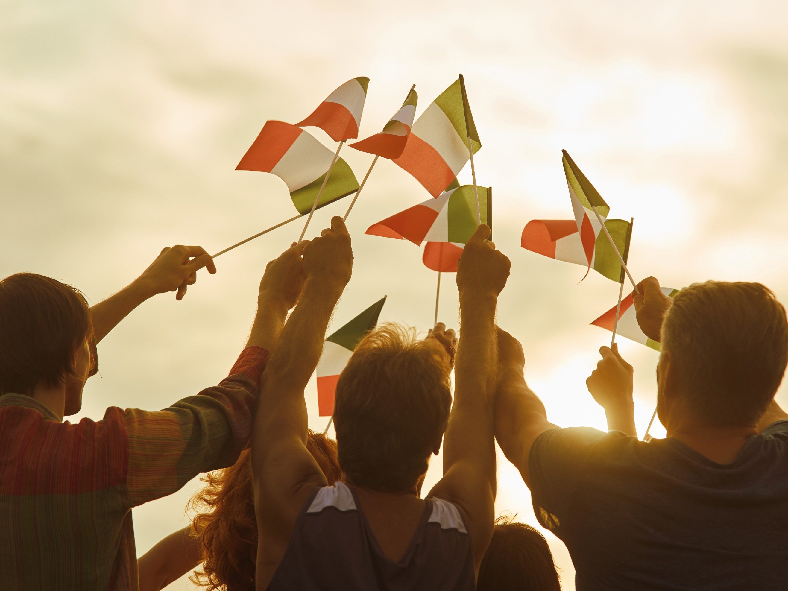 Glowing sun on patriotic italian people. Patriotic family, rear view. Evening sky.