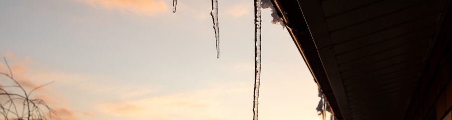icicles hanging from the edge of the roof dripping water