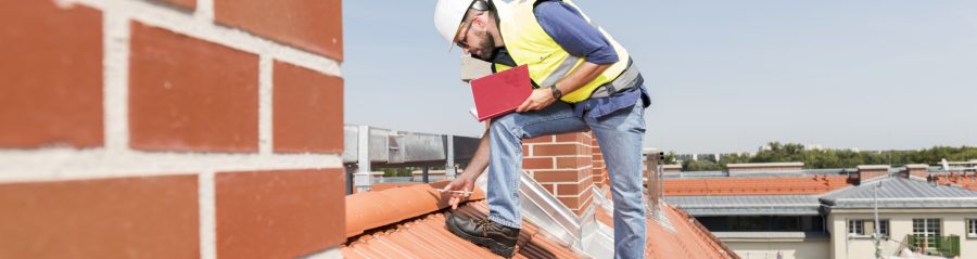 Urban roofer product manager checking ridge system wearing safety jacket and hard hat in an urban location