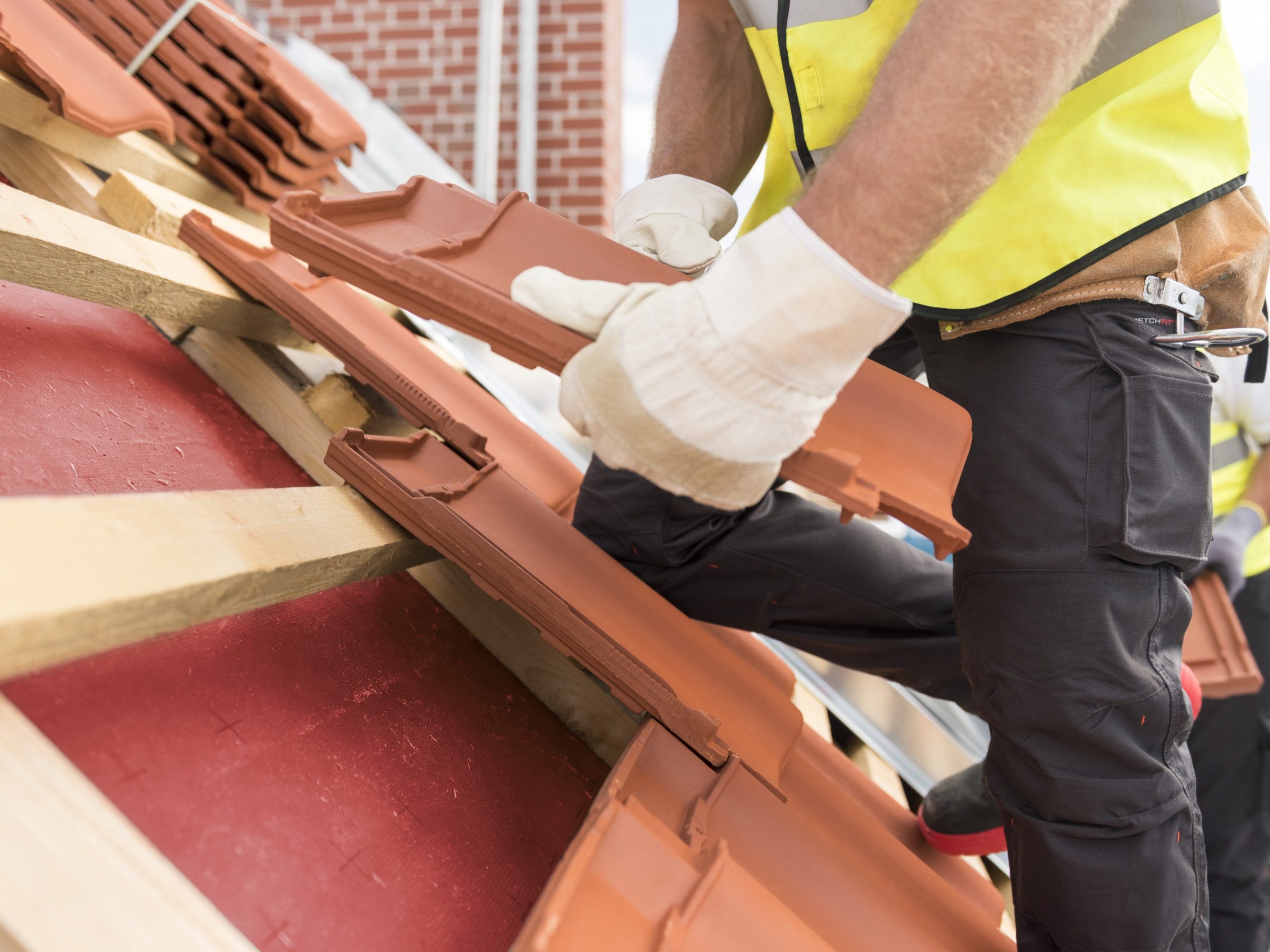 Urban roofers roof installation with Alegra roof tiles wearing safety gloves and safety jackets