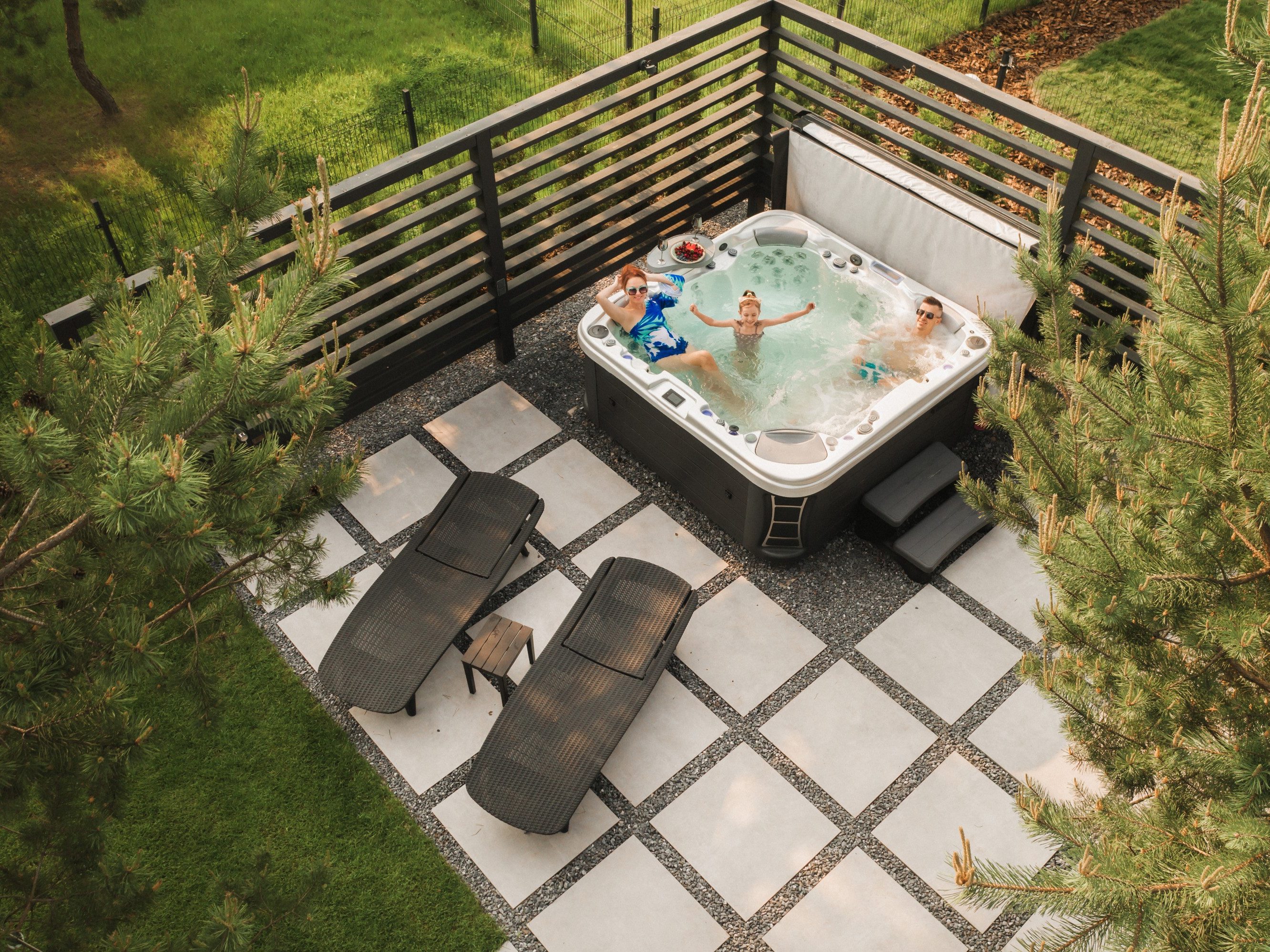 Top view of a family relaxing in an outdoor hot tub in summer.