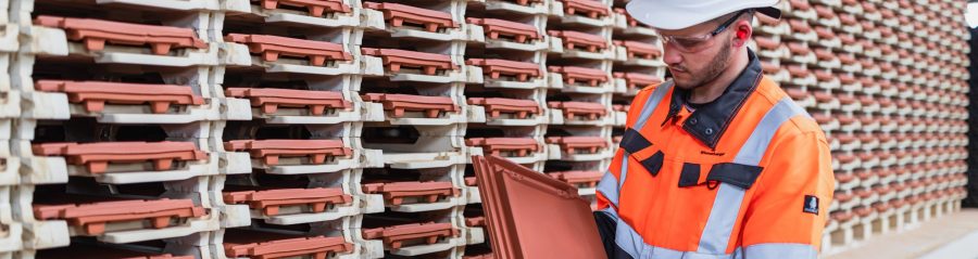 Factory worker checking roof tile quality