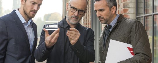 Business people and architect talking about a new building project in front of brick facade